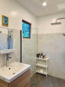 a white bathroom with a sink and a shower at Casita Ysla Tiny Home with garden kitchen wifi 2 scooters in El Nido +36 photos