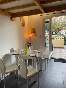 a dining room with a table and chairs and a table and chairsktop at Maison cosy Santa Barbara in Le Barcarès