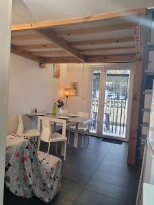 a dining room with a table and chairs and a balcony at Maison cosy Santa Barbara in Le Barcarès