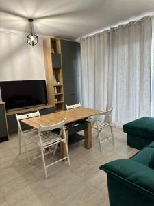 a living room with a wooden table and chairs at Apartament Bonton Predeal in Predeal
