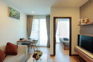 a living room with a couch and a table at The Astra condo Deluxe Room in Chiang Mai