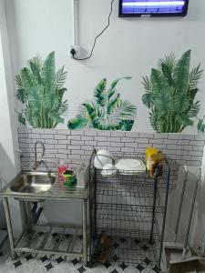 a bathroom with a sink and plants on the wall at SKY Homestay in Kota Bharu +17 photos