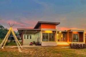 ein Haus mit einem Rasen davor in der Unterkunft Anny poolvilla 5 bedroom ATV free in Ban Lum Phli