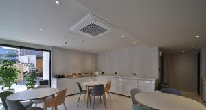 a kitchen with two tables and chairs and a counter at Jeonju It's Hotel in Jeonju