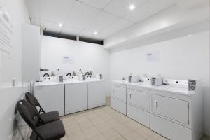 a white laboratory with sinks and washing machines at Great Southern Hotel Melbourne in Melbourne