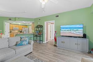 a living room with a couch and a flat screen tv at Oceanwalk 2-202 in New Smyrna Beach