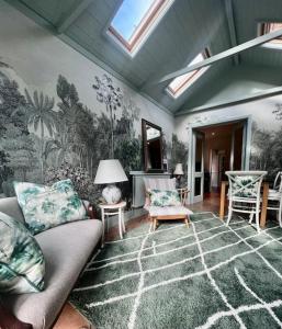 a living room with a couch and a wall mural at Gorgeous cottage in Nantwich