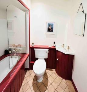 a bathroom with a toilet and a tub and a sink at Gorgeous cottage in Nantwich