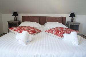 a white bed with two pillows on it at Hôtel Restaurant Le Sainte Marguerite in Pornichet