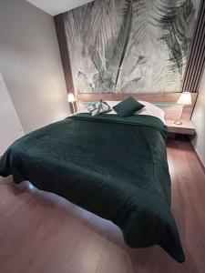 a bedroom with a green bed with a wall at Esprit Palace, coeur de Mulhouse in Mulhouse
