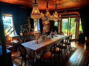 a dining room with a table with chairs and chandeliers at A Hotel Boutique Pelluhue in Pelluhue