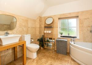 a bathroom with a sink and a tub and a toilet at Stunning 3BD Oxfordshire Cottage in Enstone in Enstone +13 photos