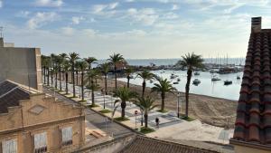a view of a street with palm trees and a harbor at Casa Frijol 20metres from the beach in Los Alcázares