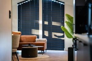 a living room with a couch and chairs and a table at Wellnesshuisje in de Sallandse Heuvelrug in Haarle
