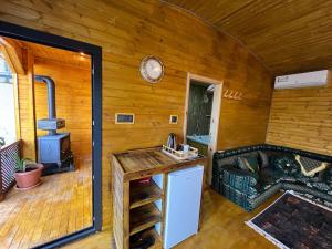 a room with a wooden wall with a kitchen and a stove at Gardan Bungalov in Çatalca