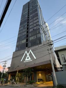 a tall building with a mactan sign on it at Premier Suites- Panoramic View in Cebu City