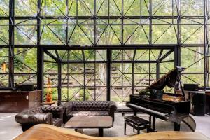 Una sala de estar con un piano y un sofá. en クリエイティブな人の遊び場!最大16名リンカンスタジオRINKAN Studio, en Ito 62 fotos más