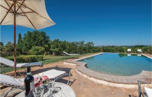 a swimming pool with a table and chairs and an umbrella at Villa Lavinia in Vitorchiano