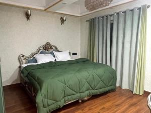 een slaapkamer met een bed met een groen dekbed bij Kamisama Boutique Stay in Vagator