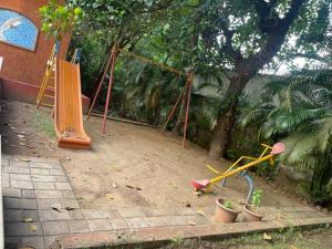 een speeltuin met schommels en potplanten in een tuin bij Kamisama Boutique Stay in Vagator