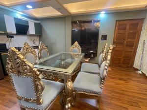 een kamer met stoelen en een glazen tafel met een glas bij Kamisama Boutique Stay in Vagator
