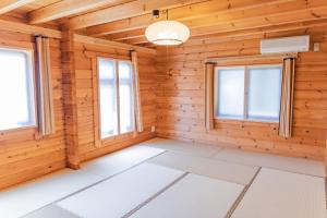 a room in a log cabin with windows at 民泊ゆとろぎ in Ema