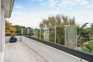 d'un balcon avec vue sur les arbres et les arbres. dans l'établissement High Tides Elegant & Modern 4-Bedroom Villa in Sandbanks, à Sandbanks