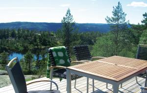 a wooden table and chairs on a deck with a view at Holiday Home Dølemo Hillestadheia Iii in Øvre Ramse