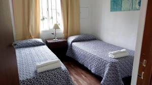 two twin beds in a room with a window at Cabaña Doña Alicia in San Rafael