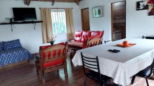 a living room with a table and chairs and a bed at Cabaña Doña Alicia in San Rafael