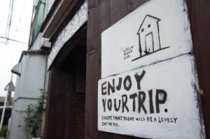 a sign on a building that reads enjoy your drip at Goto Guest House Utojuku in Goto