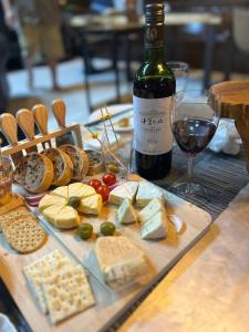 Una mesa con un montón de queso y una botella de vino. en クリエイティブな人の遊び場!最大16名リンカンスタジオRINKAN Studio, en Ito