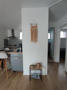 a kitchen with a table and a white wall at appartement dans maison de village in Pinet