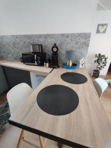 a wooden table with white chairs and a desk with a lamp at appartement dans maison de village in Pinet