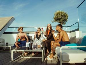 a group of people sitting on the deck of a yacht at Number 11 St Julian's Malta - Handwritten Collection in St. Julianʼs