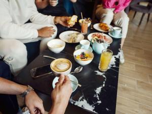 a group of people sitting around a table eating food at Number 11 St Julian's Malta - Handwritten Collection in St. Julianʼs