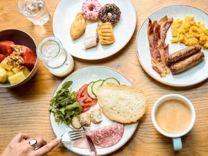 a wooden table with plates of breakfast food on it at Number 11 St Julian's Malta - Handwritten Collection in St. Julianʼs