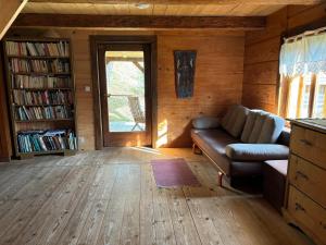 a living room with a couch and a book shelf at Slow House in Polany
