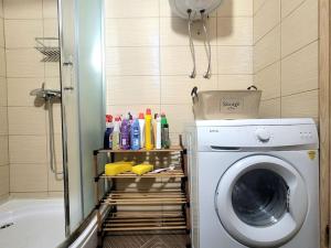 a bathroom with a washing machine and a shower at Geon Apartament in Prishtinë