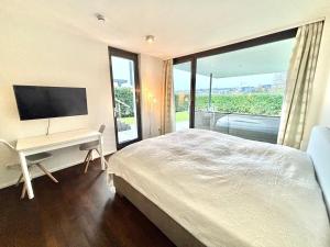 a bedroom with a bed and a desk with a television at Studio Apartment direkt am Phoenixsee in Dortmund