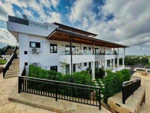 a large white house with a balcony on top of it at Moshono Hillside in Arusha