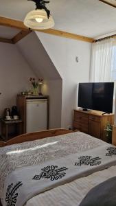 a bedroom with a bed and a flat screen tv at Willa Świerk - Panorama Tatr in Zakopane +40 photos