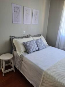 a small bedroom with a bed and a stool at Refúgio Cantinho Verde in Pinto Bandeira +37 photos