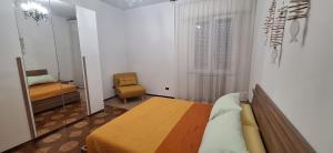 a bedroom with a bed and a chair and a mirror at Casariosa, centro Rimini in Rimini