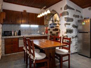 a kitchen with a wooden table and a stone wall at Casinha dos cinco sentidos in Nordestinho