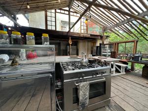 a kitchen with a stove top oven in aestead at Stormsriver Backpackers Dijembe in Stormsrivier
