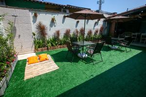 a patio with a table and chairs and an umbrella at Pousada Petit Refuge in Juquei