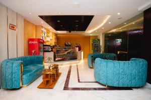a lobby with two blue chairs and a table at Royal Raj Hotel in Rājshāhi
