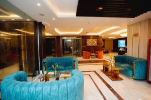 a lobby with two blue chairs and a glass table at Royal Raj Hotel in Rājshāhi