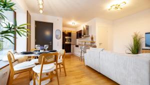 a dining room and living room with a table and chairs at NaturOase, Moderne Architektur - Arbeitsplatz - Klimaanlage - Parkplatz - Waschmaschine in Vöhringen +7 photos